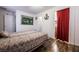 Well-lit bedroom with wood-look flooring, a picture on the wall, and a bathroom doorway at 1035 Spotted Saddle St, Henderson, NV 89015