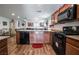 Open kitchen featuring granite countertops, a black appliance package, and wood-look flooring at 1035 Spotted Saddle St, Henderson, NV 89015