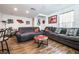 Open-concept living room with a gray sofa, wood-style flooring, and a view of the adjacent dining area at 1035 Spotted Saddle St, Henderson, NV 89015
