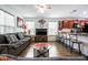 Open concept living room featuring a gray sofa, modern decor, wood flooring, and a view into the kitchen at 1035 Spotted Saddle St, Henderson, NV 89015
