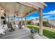 Relaxing covered patio with ceiling fan and furniture overlooking the landscaped backyard at 1066 Vanlier Ln, Henderson, NV 89015