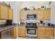 Bright kitchen features oak cabinetry, granite counters, and stainless steel appliances at 1066 Vanlier Ln, Henderson, NV 89015