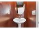 Cozy half bathroom with a pedestal sink, oval mirror, and decorative walls at 10830 Space Odyssey Ave, Las Vegas, NV 89129