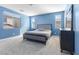 Bright bedroom featuring neutral carpet, a window with blinds, and a bed with gray comforter at 10830 Space Odyssey Ave, Las Vegas, NV 89129