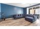 Bright living room featuring wood floors, a comfortable sectional sofa, and sliding glass doors at 10830 Space Odyssey Ave, Las Vegas, NV 89129