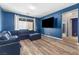 Comfortable living room features wood floors, large sectional sofa, and a wall-mounted television at 10830 Space Odyssey Ave, Las Vegas, NV 89129