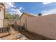 Fenced backyard area with access gate, featuring a mix of gravel and hardscape, offering privacy and security at 1133 Mount Olympias Ct, Las Vegas, NV 89110