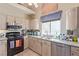Bright kitchen featuring granite countertops, a stainless-steel dishwasher, and modern appliances at 1133 Mount Olympias Ct, Las Vegas, NV 89110