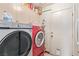 Well-organized laundry room featuring modern, front-loading washer and dryer units with ample cabinet storage above at 1133 Mount Olympias Ct, Las Vegas, NV 89110