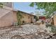 Charming backyard patio with stone accents and mature trees providing shade and privacy at 1200 I Ave, Boulder City, NV 89005