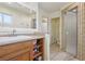 Bright bathroom with a vanity, large mirror, and tiled walk-in shower with a glass door at 1200 I Ave, Boulder City, NV 89005