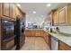 Open kitchen features stainless steel appliances, wood cabinetry, and a granite countertop at 1200 I Ave, Boulder City, NV 89005
