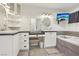 Spa-like primary bathroom with dual sinks, a vanity area, white cabinetry and a soaking tub at 1200 I Ave, Boulder City, NV 89005