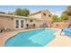 Backyard pool with lounge chairs, patio furniture, and string lights, perfect for relaxing and entertaining at 1200 I Ave, Boulder City, NV 89005