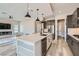 Open-concept kitchen featuring an island with seating, stainless appliances, and stylish pendant lights at 138 Crimson Cactus Ave, Henderson, NV 89011