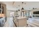 Open-concept kitchen featuring an island with quartz countertops, stainless steel appliances, and a view of the living room at 138 Crimson Cactus Ave, Henderson, NV 89011