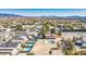 Aerial view of a neighborhood with a swimming pool, lush yards, and landscaping against a desert backdrop at 1410 E Serene Ave, Las Vegas, NV 89123