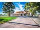 Charming single-story home features a red-tiled roof, arched entryway, a spacious driveway, and well-manicured lawn at 1410 E Serene Ave, Las Vegas, NV 89123