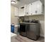 A complete laundry setup with stainless steel machines, and white storage cabinets at 1410 E Serene Ave, Las Vegas, NV 89123