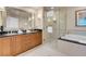 Bright bathroom featuring double vanity, soaking tub, and glass-enclosed shower for a spa-like experience at 145 E Harmon Ave # 2411, Las Vegas, NV 89109