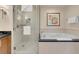 Bright bathroom featuring shower, soaking tub, art, and white towels at 145 E Harmon Ave # 2411, Las Vegas, NV 89109