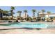A shimmering swimming pool surrounded by palm trees, cabanas, and lounge chairs on a sunny day at 145 E Harmon Ave # 2411, Las Vegas, NV 89109