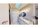 Bathroom with skylight, white vanity, granite countertop and modern fixtures at 1466 Fieldbrook St, Henderson, NV 89052