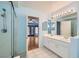 Tiled bathroom with double sinks, shower and doorway to bedroom at 1751 Juniper Twig Ave, Las Vegas, NV 89183