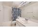 Well-lit bathroom featuring a shower-tub combo, large vanity mirror, and neutral color scheme at 1751 Juniper Twig Ave, Las Vegas, NV 89183