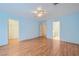 Large bedroom with a ceiling fan, wood floors, and doorways to a bathroom and closet at 1751 Juniper Twig Ave, Las Vegas, NV 89183