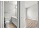 Bathroom featuring tile floors, a toilet, and a vanity with a mirror; bedroom with plank flooring visible at 1800 Edmond St # 226, Las Vegas, NV 89146