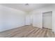 Bright bedroom with white walls, wood-look floors, closet, and open door to a connected laundry room at 1905 Aquarius Dr, Las Vegas, NV 89102
