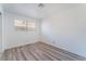 Well-lit bedroom showcasing wood-look floors and a window overlooking the property at 1905 Aquarius Dr, Las Vegas, NV 89102
