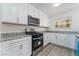 Updated kitchen featuring granite countertops, white cabinets, stainless steel appliances, and new flooring at 1905 Aquarius Dr, Las Vegas, NV 89102