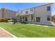 Home backyard with lush artificial grass, covered patio, and second story balcony perfect for enjoying private outdoor moments at 191 Reed Ln, Henderson, NV 89074