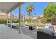 Relaxing backyard showcasing a stone patio with outdoor seating, well-maintained lawn, and lush landscaping for enjoyable outdoor space at 191 Reed Ln, Henderson, NV 89074