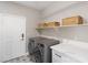 Bright laundry room with modern washer/dryer, white countertop, and shelving for storage at 191 Reed Ln, Henderson, NV 89074