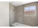 Modern shower with light gray tiling, glass enclosure and honeycomb tile floor at 191 Reed Ln, Henderson, NV 89074