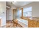 Bathroom featuring a shower, tub, tile floors, and arched doorway with a sink and wooden cabinets at 1933 Coralino Dr, Henderson, NV 89074