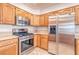 Spacious kitchen with stainless steel appliances, wooden cabinetry, and tiled floors at 1933 Coralino Dr, Henderson, NV 89074