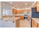 Well-lit kitchen featuring light wooden cabinets, stainless steel appliances, and tile flooring at 1933 Coralino Dr, Henderson, NV 89074