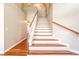 Bright two-story foyer with wooden staircase and white risers and railings at 1933 Coralino Dr, Henderson, NV 89074