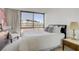 Bedroom featuring a comfortable bed, chair, and a large window with city views at 205 E Harmon Ave # 306, Las Vegas, NV 89169