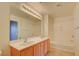 Bright bathroom featuring a double sink vanity, large mirror, and shower over tub at 23 E Agate Ave # 207, Las Vegas, NV 89123