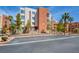 Exterior of the condo building shows the architectural style with palm trees and parking spots out front at 23 E Agate Ave # 207, Las Vegas, NV 89123