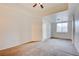 Spacious main bedroom with neutral walls, carpet flooring, ceiling fan, and large windows at 23 E Agate Ave # 207, Las Vegas, NV 89123