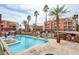 Resort-style pool with sun loungers and palm trees amidst the condo buildings in a well-maintained community at 23 E Agate Ave # 207, Las Vegas, NV 89123