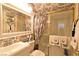 Well-maintained bathroom with a glass door shower, vanity, and decorated with matching wallpaper at 2305 Flower Spring St, Las Vegas, NV 89134