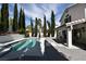 Backyard pool and patio area featuring tall trees and outdoor seating at 2305 Flower Spring St, Las Vegas, NV 89134