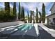 Backyard pool and spa surrounded by trees and with a patio area with outdoor furniture at 2305 Flower Spring St, Las Vegas, NV 89134